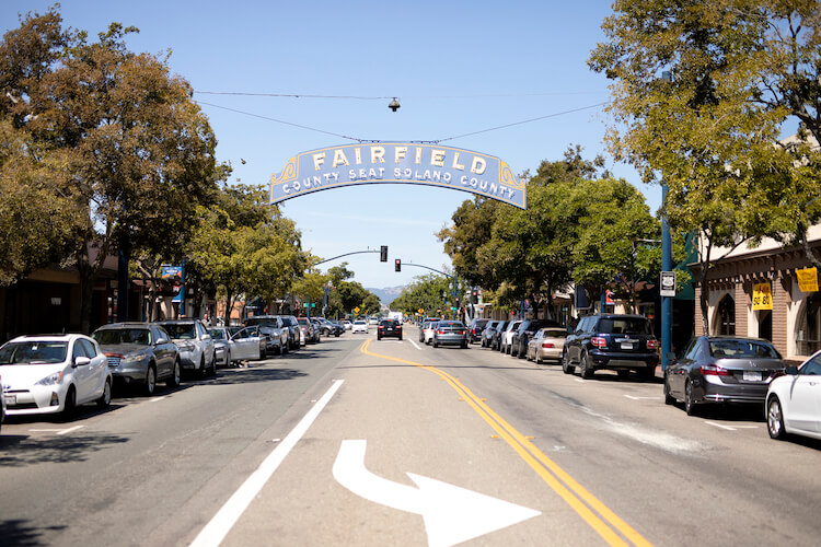 Fairfield, CA city street with sign on city name hanging across
